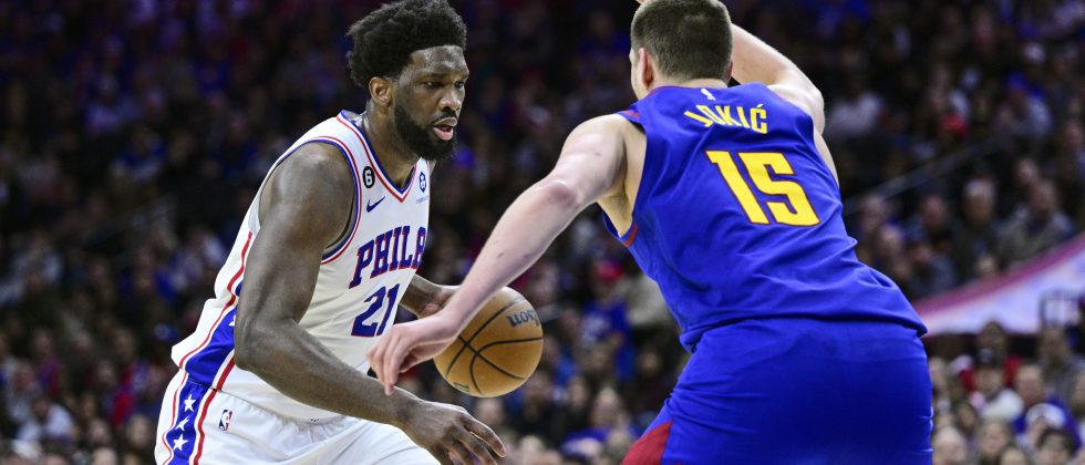 Philadelphia 76ers' Joel Embiid, left, dribbles the ball against Denver Nuggets' Nikola Jokic during the second half of an NBA basketball game, Saturday, Jan. 28, 2023, in Philadelphia. (AP Photo/Derik Hamilton)